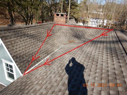 Asphalt shingle roof with red lines drawn from chimney down the valley toward a low corner