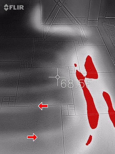 Thermal camera image of a tile floor showing warm bands from radiant floor heating, spot reading 68.5 degrees.