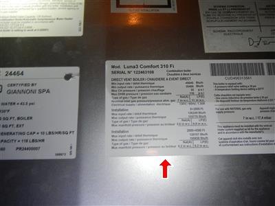 Manufacturer data plate on a boiler listing model, serial number, and input ratings, red arrow