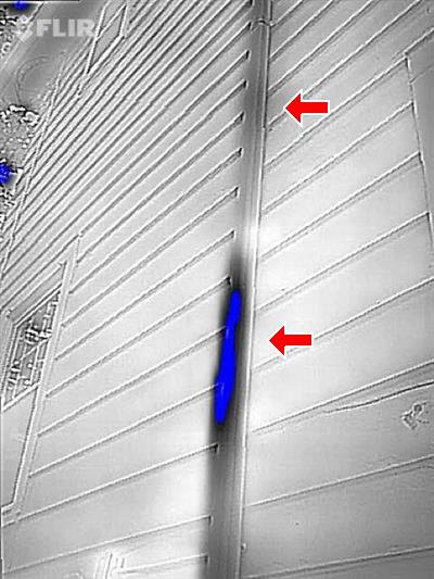 Thermal image with red arrows at a blue cold streak along an uninsulated pipe run