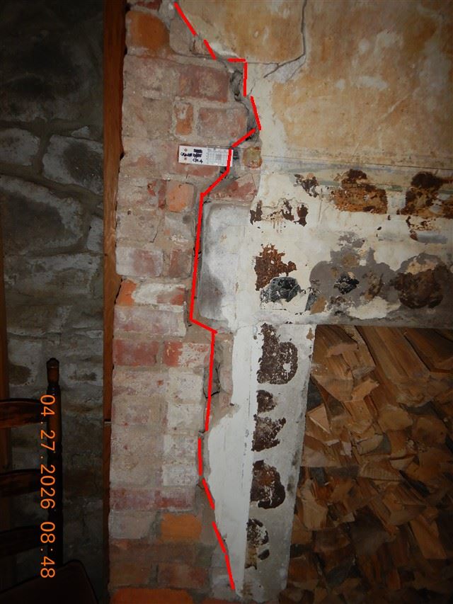 A masonry wall with deteriorated mortar and spalled brick, outlined in the inspection report.