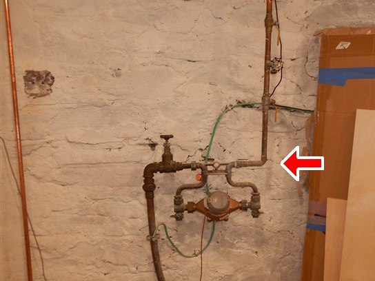 The water service where it enters the cellar - shut-off, meter and bonding jumper.
