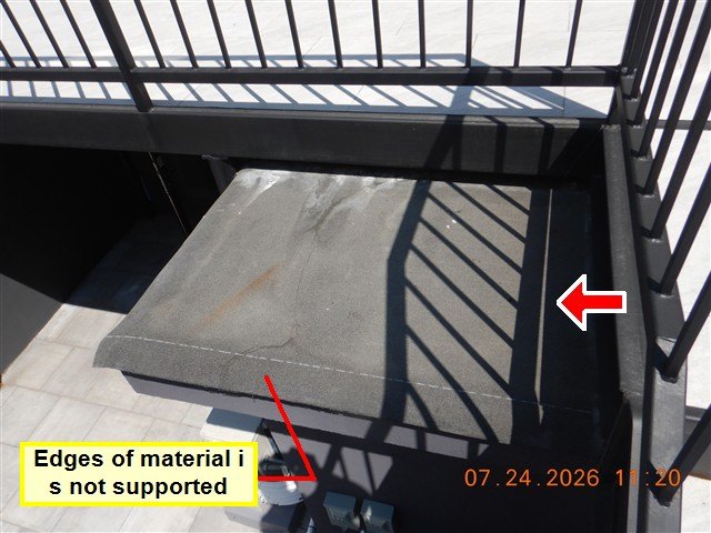 A small extension roof beside an iron railing, with a burned-in label reading 'Edges of material is not supported'.