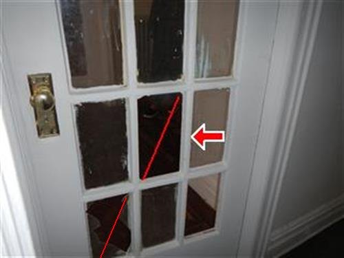 A white-painted glass-panelled interior door with red lines tracing panes where glass is missing.