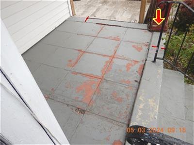 Painted porch floor with worn, peeling paint; a yellow arrow and red marks flag the right side near the steps