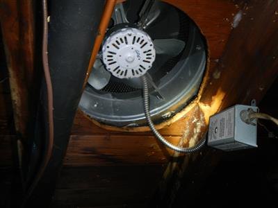 An attic exhaust fan with a thermostat control box, connected by flexible metal conduit.