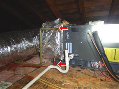 Attic air handler with foil-wrapped duct, red arrows marking uninsulated heat pipes.